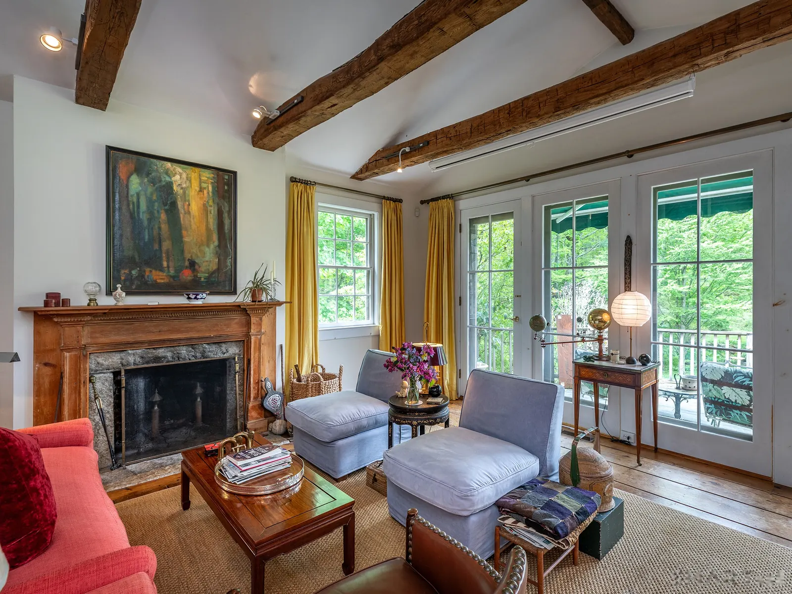 Main-house sitting room with fireplace, art, and garden doors