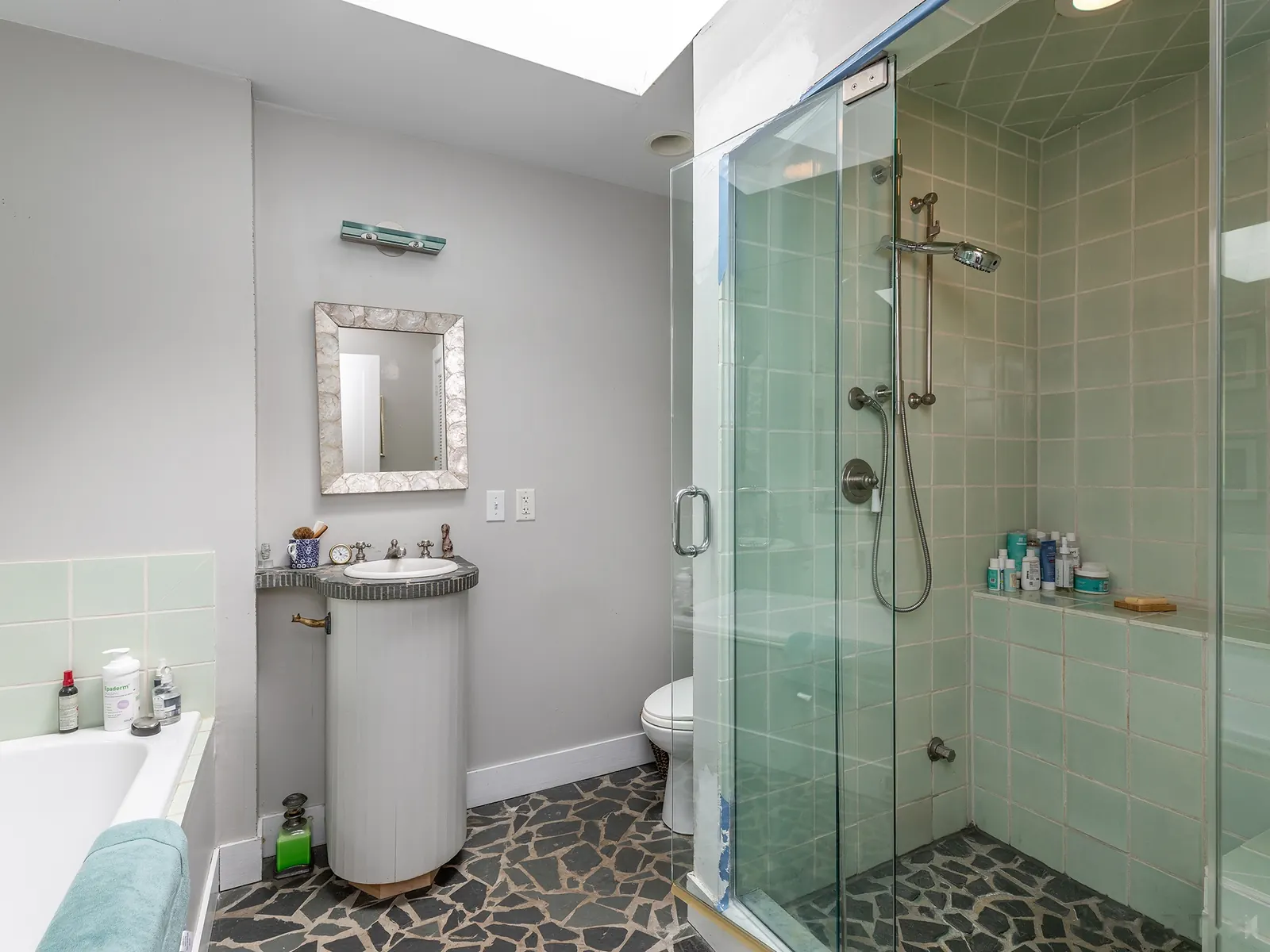 Main-house bath with green tile and stone floor